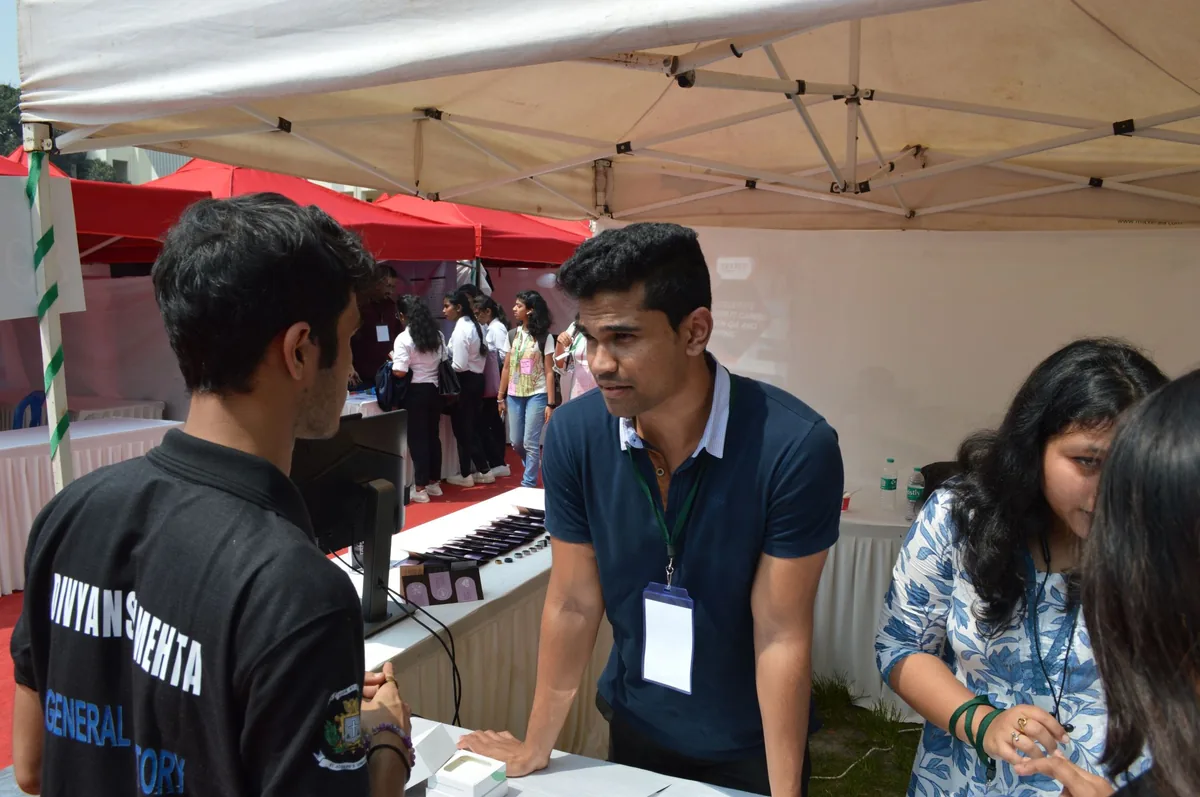 An attendee speaking with a startup representative at an exhibitor booth during Startup Mela